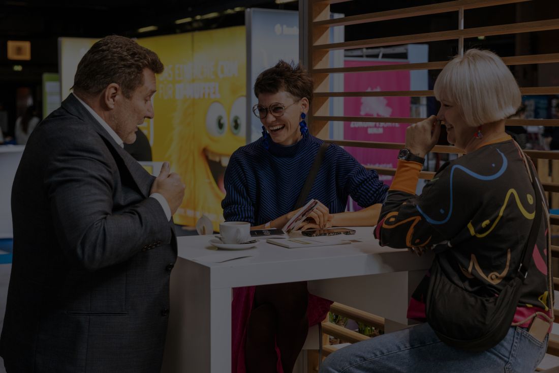 Anmeldung Aussteller. Berater und Besucher:innen lachen zusammen